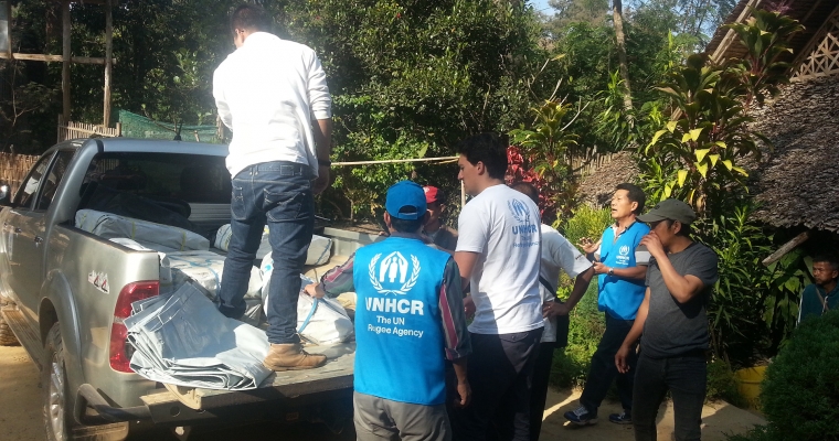 เจ้าหน้าที่ UNHCR กำลังขนแผ่นพลาสติกเพื่อแจกจ่ายให้กับผู้ลี้ภัยที่ได้รับผลกระทบจากเหตุการณ์ไฟไหม้